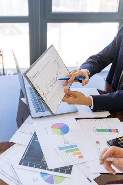 Calculadora, lapiz y papeles con numeros sobre una mesa de trabajo